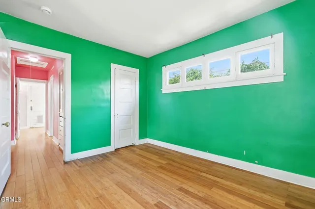 a view of a room that has a window and wooden floor