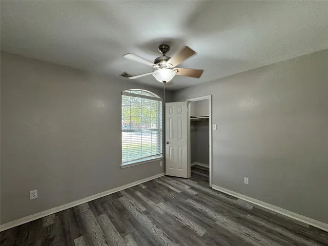 an empty room with fan and windows