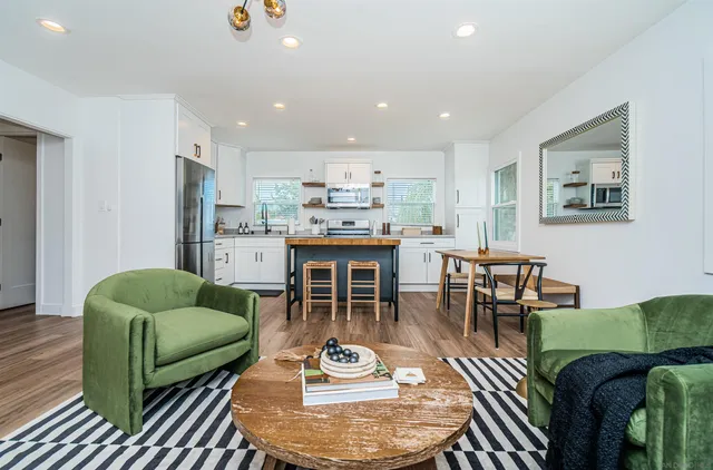 a living room with furniture and a dining table with kitchen view