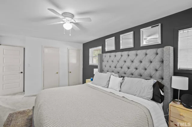 a bedroom with a large bed and a chandelier