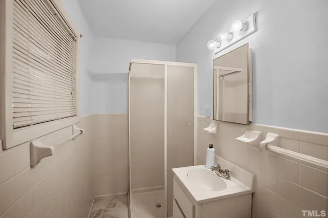 a bathroom with a sink mirror and shower