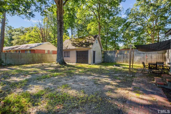 a view of a house with backyard and a tree