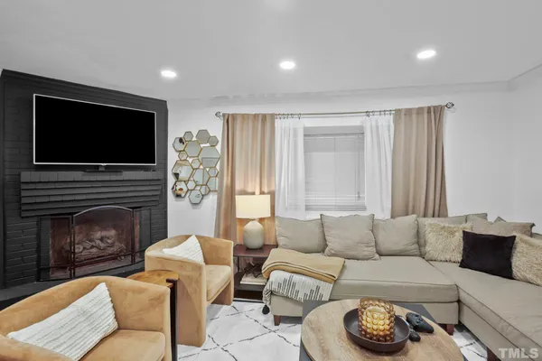 a living room with furniture a flat screen tv and a fireplace