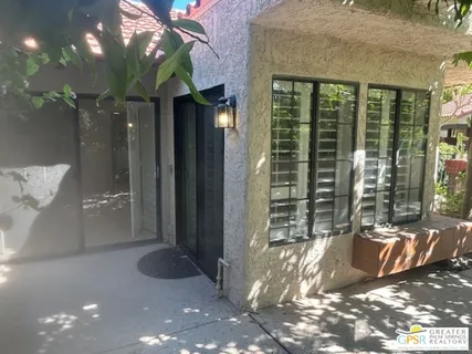 a view of backyard with large tree and wooden fence