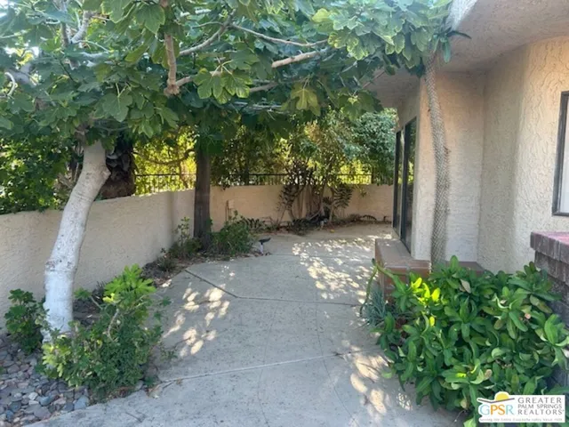 a vase of flowers sitting on a floor in front of a house