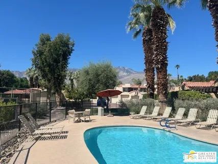 a view of a swimming pool with a patio and plants