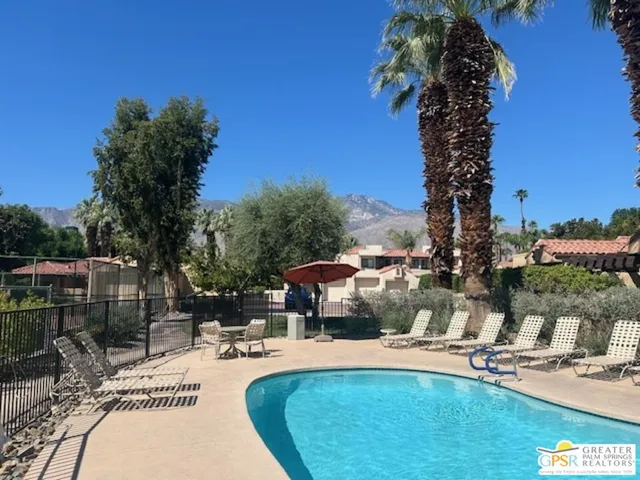 a view of a swimming pool with a patio and plants