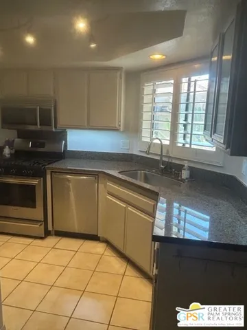 a kitchen with stainless steel appliances granite countertop a sink and a stove