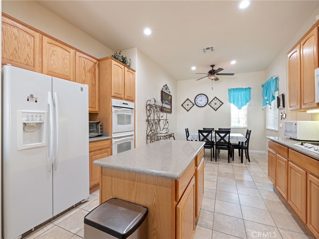 10588 Archerwill Road Apple Valley, CA 92308 - Photo 17 of 35 a kitchen with granite countertop a refrigerator a sink a stove top oven a dining table and chairs