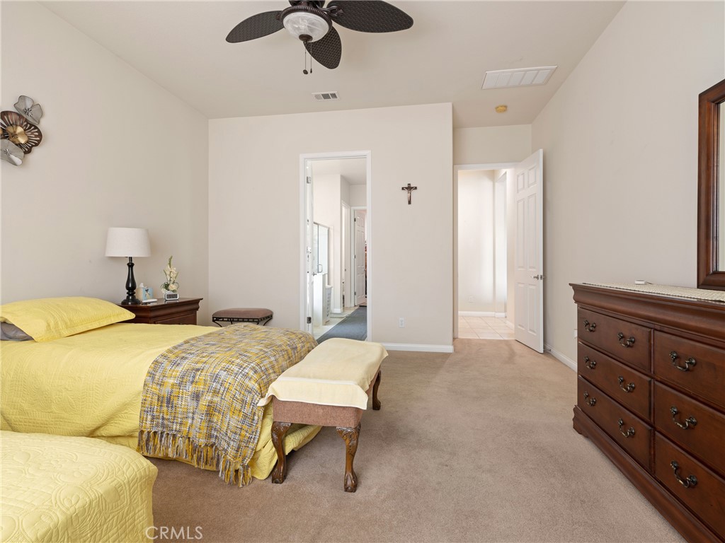 10588 Archerwill Road Apple Valley, CA 92308 - Photo 22 of 35 a bedroom with a bed and ceiling fan