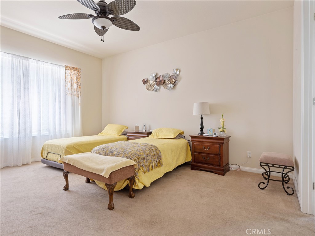 10588 Archerwill Road Apple Valley, CA 92308 - Photo 23 of 35 a bedroom with a bed and a chandelier