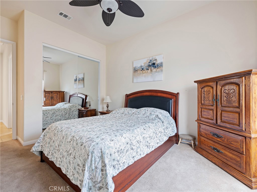 10588 Archerwill Road Apple Valley, CA 92308 - Photo 26 of 35 a bedroom with a bed and dresser with mirror