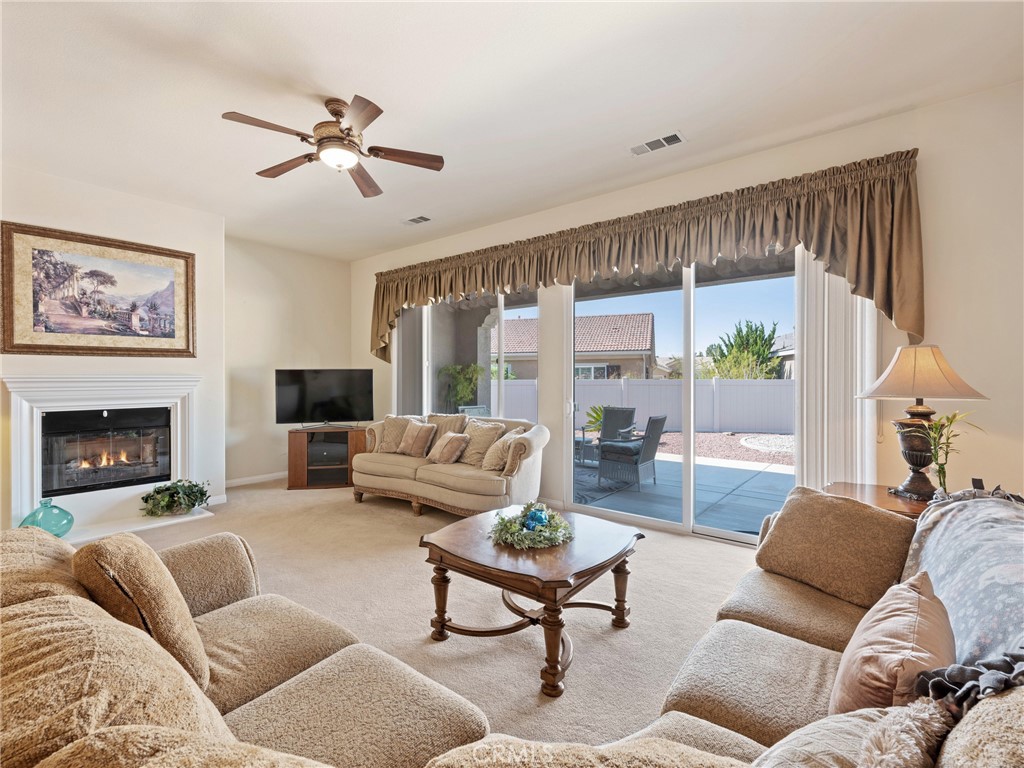 10588 Archerwill Road Apple Valley, CA 92308 - Photo 5 of 35 a living room with furniture fireplace and a large window
