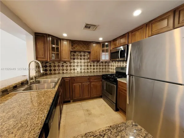 a kitchen with stainless steel appliances a refrigerator sink and stove