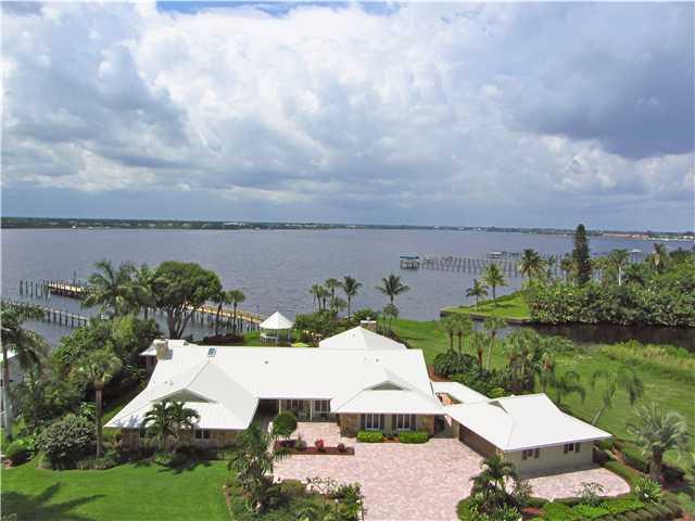 2640 Northwest Collins Cove Road Stuart, FL 34994 - Photo 1 of 21 an aerial view of a house with garden space and lake view in back
