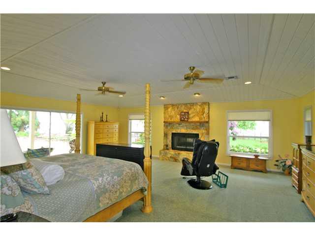 2640 Northwest Collins Cove Road Stuart, FL 34994 - Photo 11 of 21 a bedroom with furniture and a large window