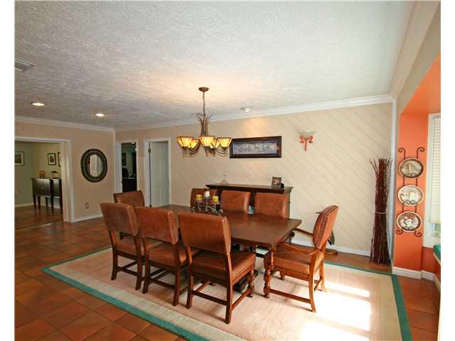 2640 Northwest Collins Cove Road Stuart, FL 34994 - Photo 10 of 21 a view of a dining room and livingroom with furniture wooden floor a rug a painting and a chandelier