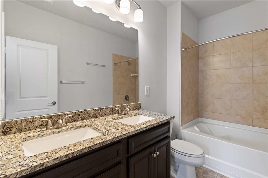 3437 Sumersbe Court Atlanta, GA 30349 - Photo 14 of 25 a bathroom with a granite countertop bathtub sink vanity mirror and toilet