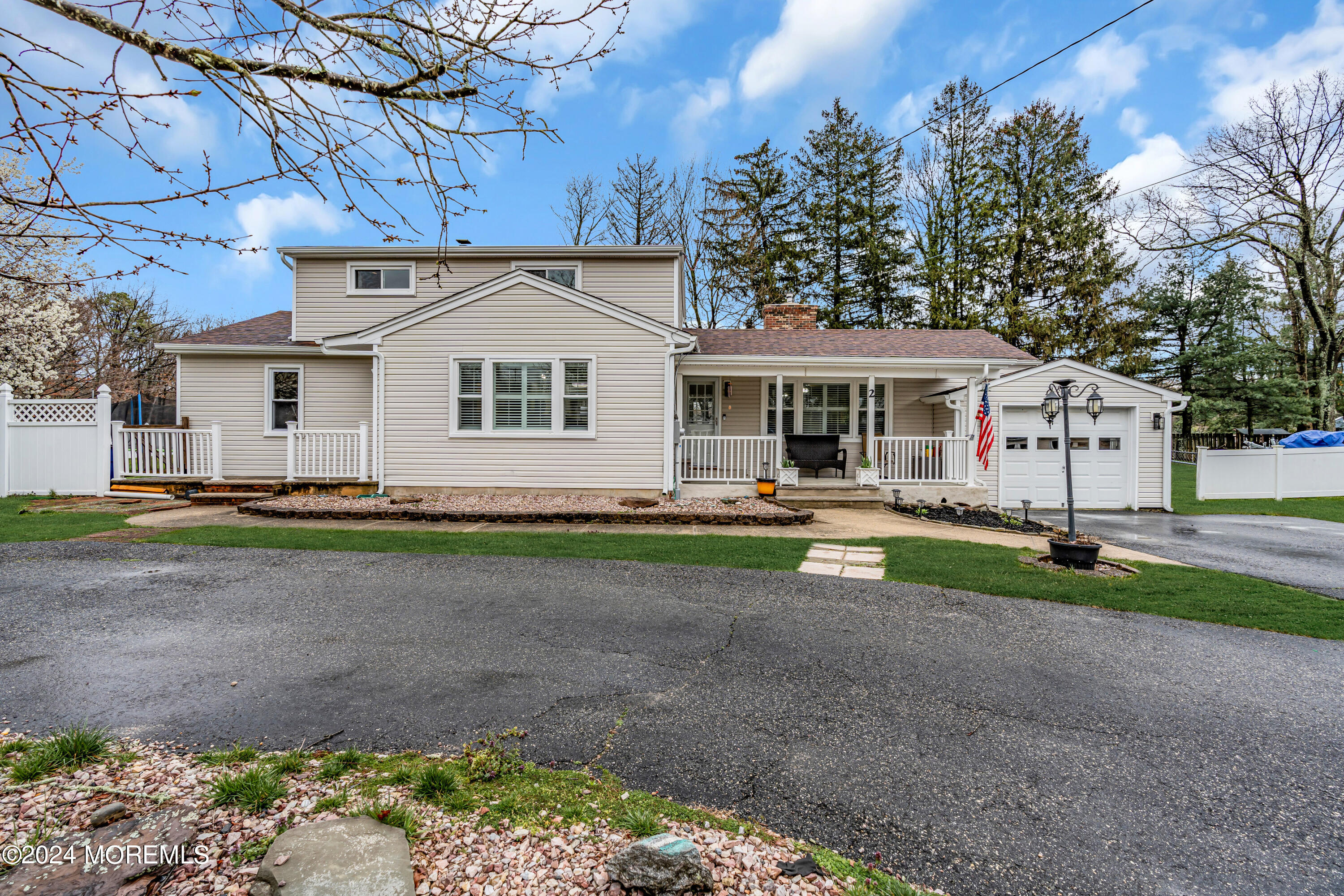 a view of a white house with a yard and a large tree