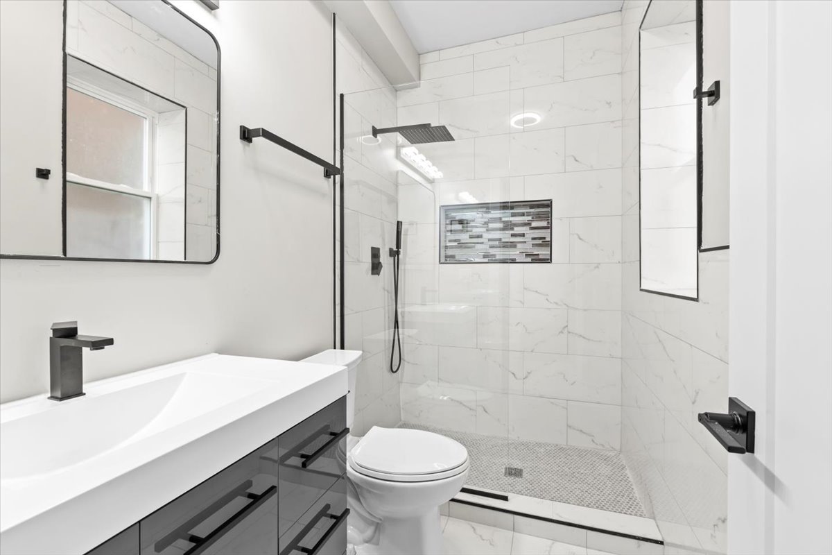 6128 South Rhodes Avenue, Unit 1 Chicago, IL 60637 - Photo 12 of 12 a bathroom with a sink a toilet a shower and a mirror