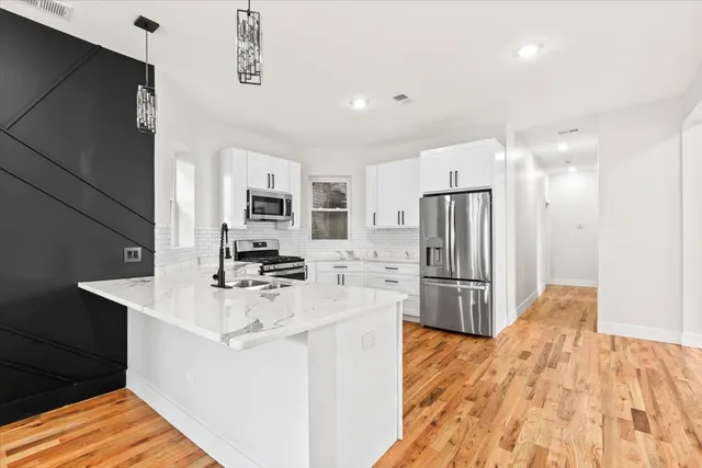 a kitchen with stainless steel appliances a refrigerator and a stove top oven