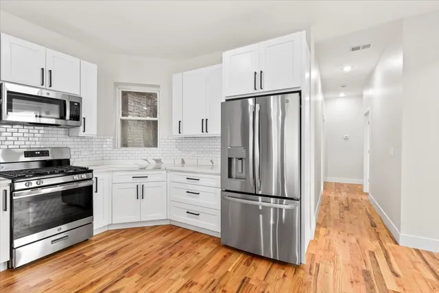 a kitchen with granite countertop a refrigerator stove and sink