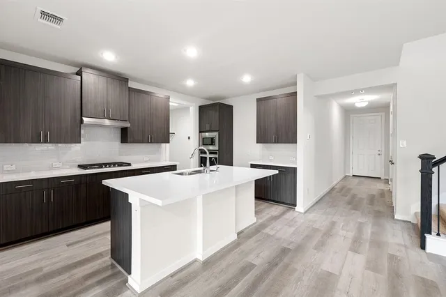 a kitchen with a sink stove and refrigerator