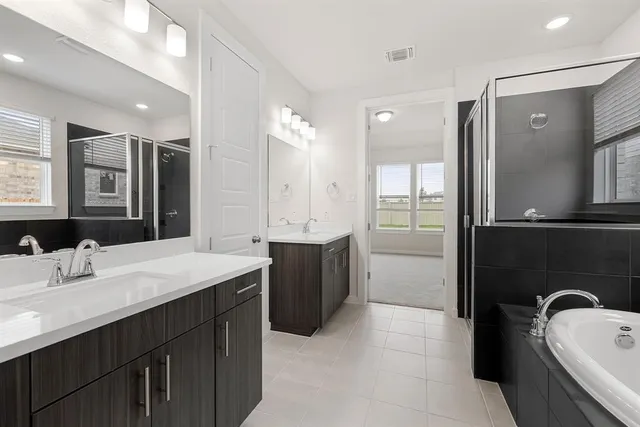 a bathroom with a tub sink and mirror