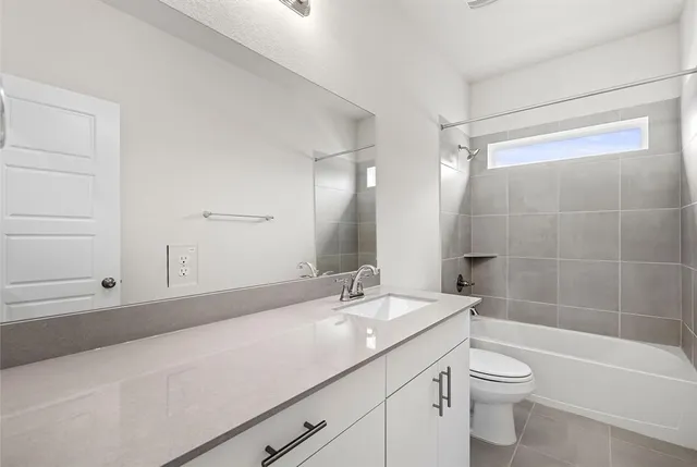 a bathroom with a granite countertop sink a toilet and shower