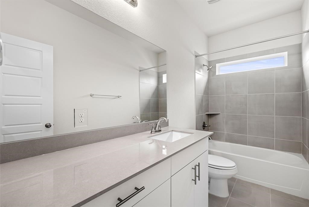 112 Alicante Lane Georgetown, TX 78628 - Photo 15 of 36 a bathroom with a granite countertop sink a toilet and shower