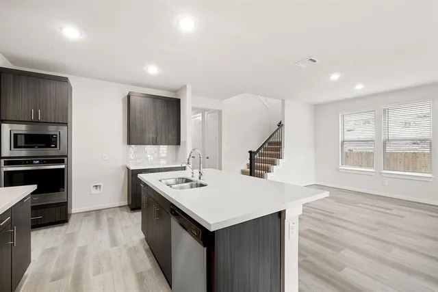 a kitchen with a stove a refrigerator and a sink