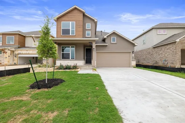 a front view of a house with a garden and plants
