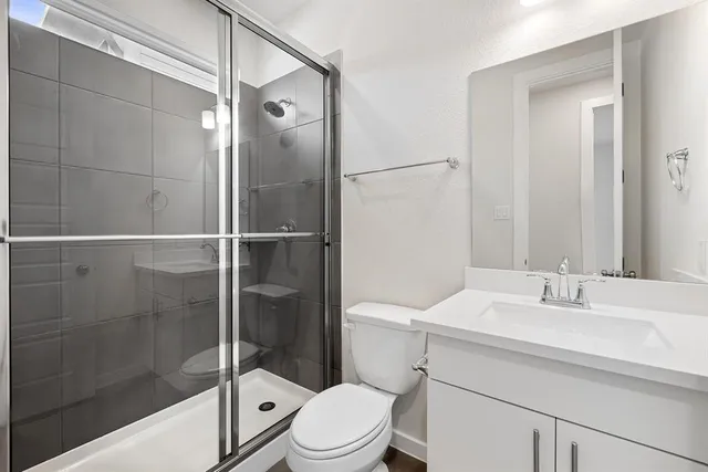 a bathroom with a sink a toilet and shower