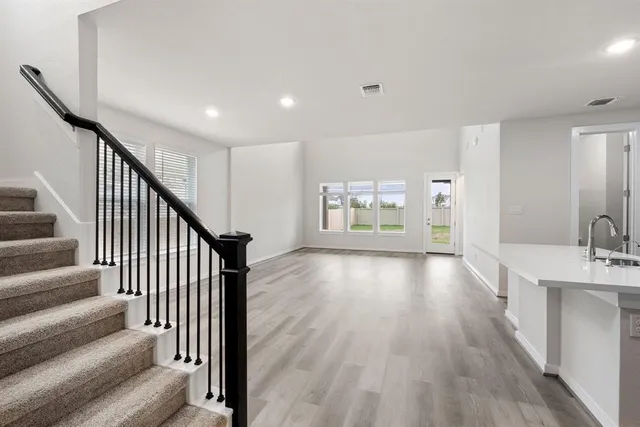 a view of a hallway with wooden floor and staircase