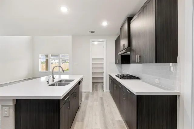 a kitchen with stainless steel appliances a sink stove and cabinets