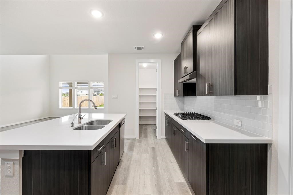 112 Alicante Lane Georgetown, TX 78628 - Photo 7 of 36 a kitchen with stainless steel appliances a sink stove and cabinets