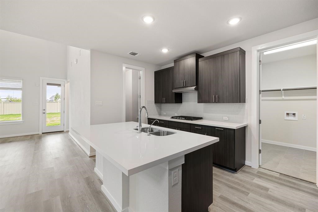 112 Alicante Lane Georgetown, TX 78628 - Photo 8 of 36 a kitchen with a sink a stove a refrigerator and a cabinets