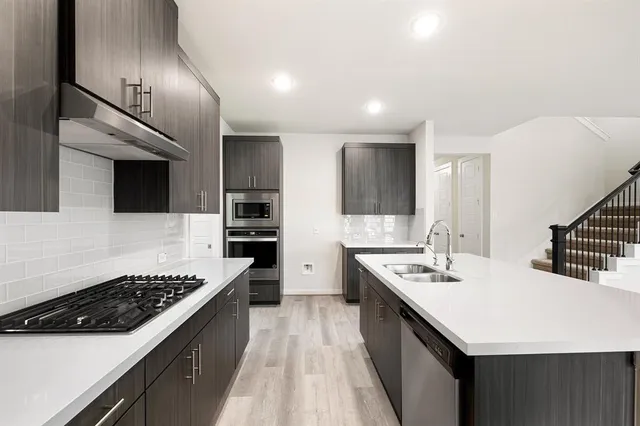 a kitchen with a sink a stove and cabinets