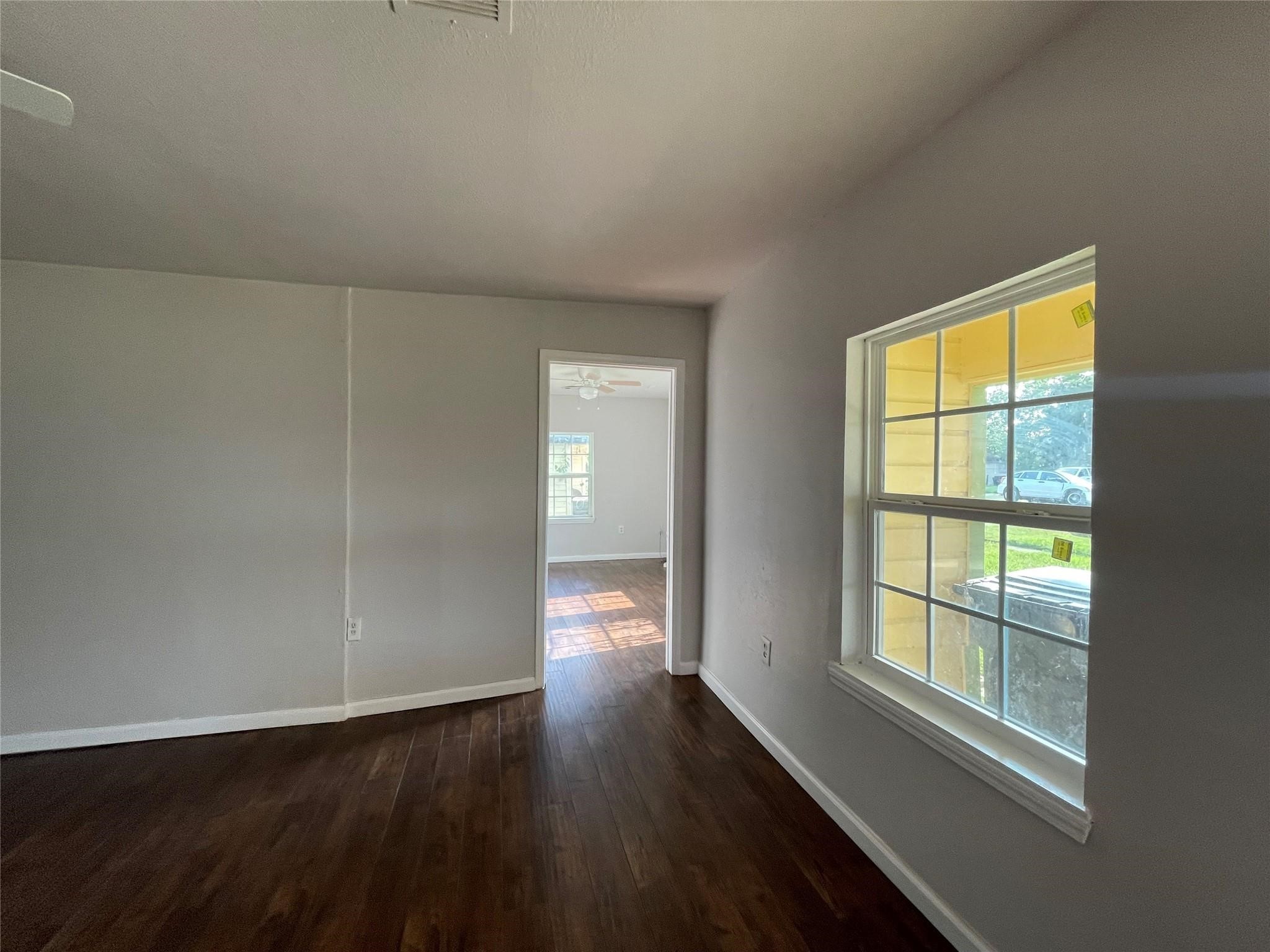 7227 St Augustine Street Houston, TX 77021 - Photo 4 of 20 a view of an empty room with wooden floor and a window