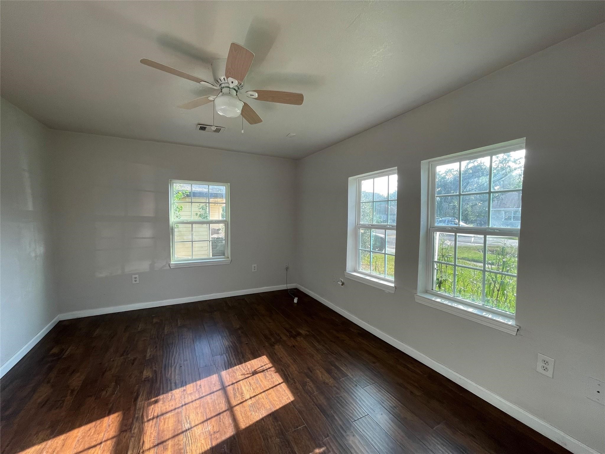 7227 St Augustine Street Houston, TX 77021 - Photo 5 of 20 a view of an empty room with wooden floor and a window