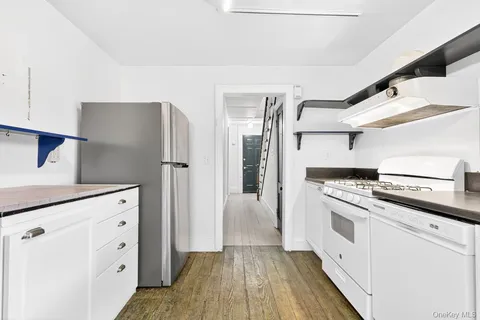 a kitchen with white cabinets and white appliances