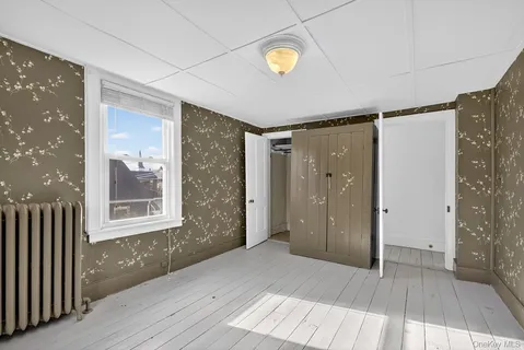 a view of a room with wooden floor and entryway