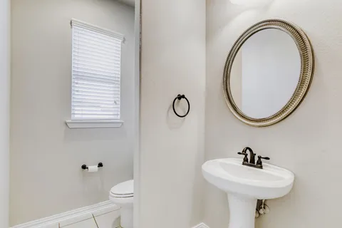 a bathroom with a sink a toilet and a mirror