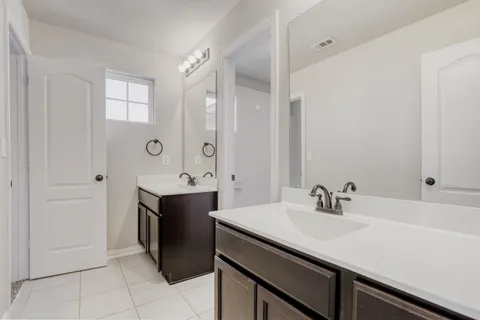 a bathroom with a sink vanity granite tub and a mirror
