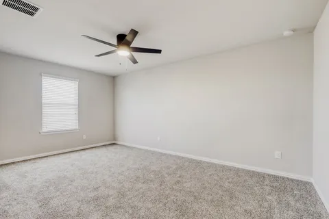 an empty room with windows and fan