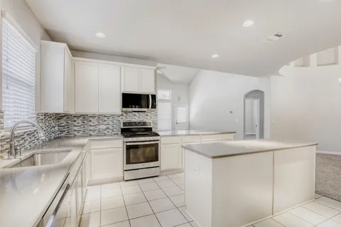 a kitchen with a sink stove and microwave