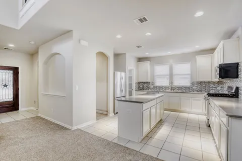a kitchen with stainless steel appliances granite countertop a refrigerator and a stove top oven
