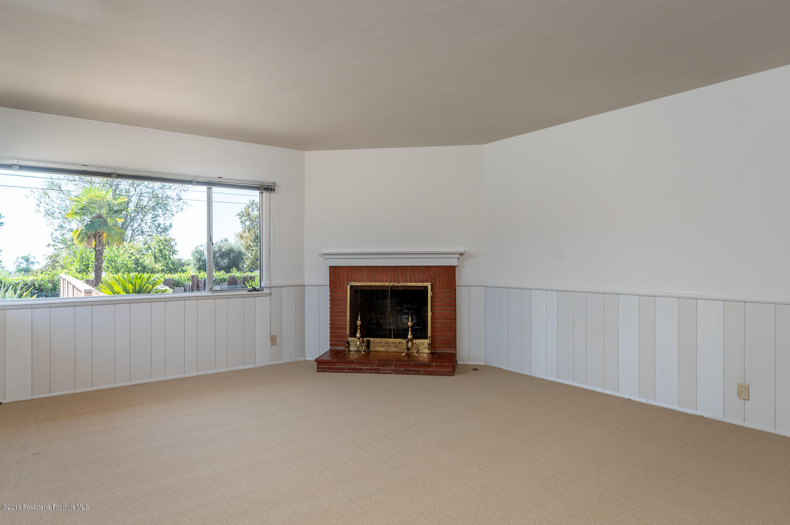 3810 Greenhill Road Pasadena, CA 91107 - Photo 15 of 29 an empty room with a fireplace and large windows