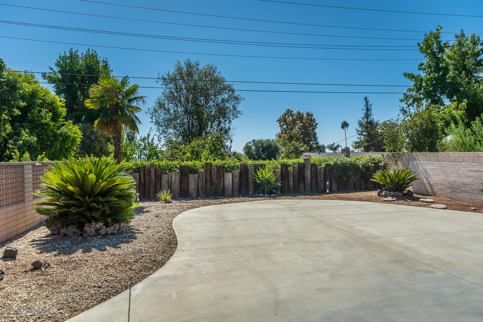 3810 Greenhill Road Pasadena, CA 91107 - Photo 28 of 29 a white house with a small yard plants and palm trees