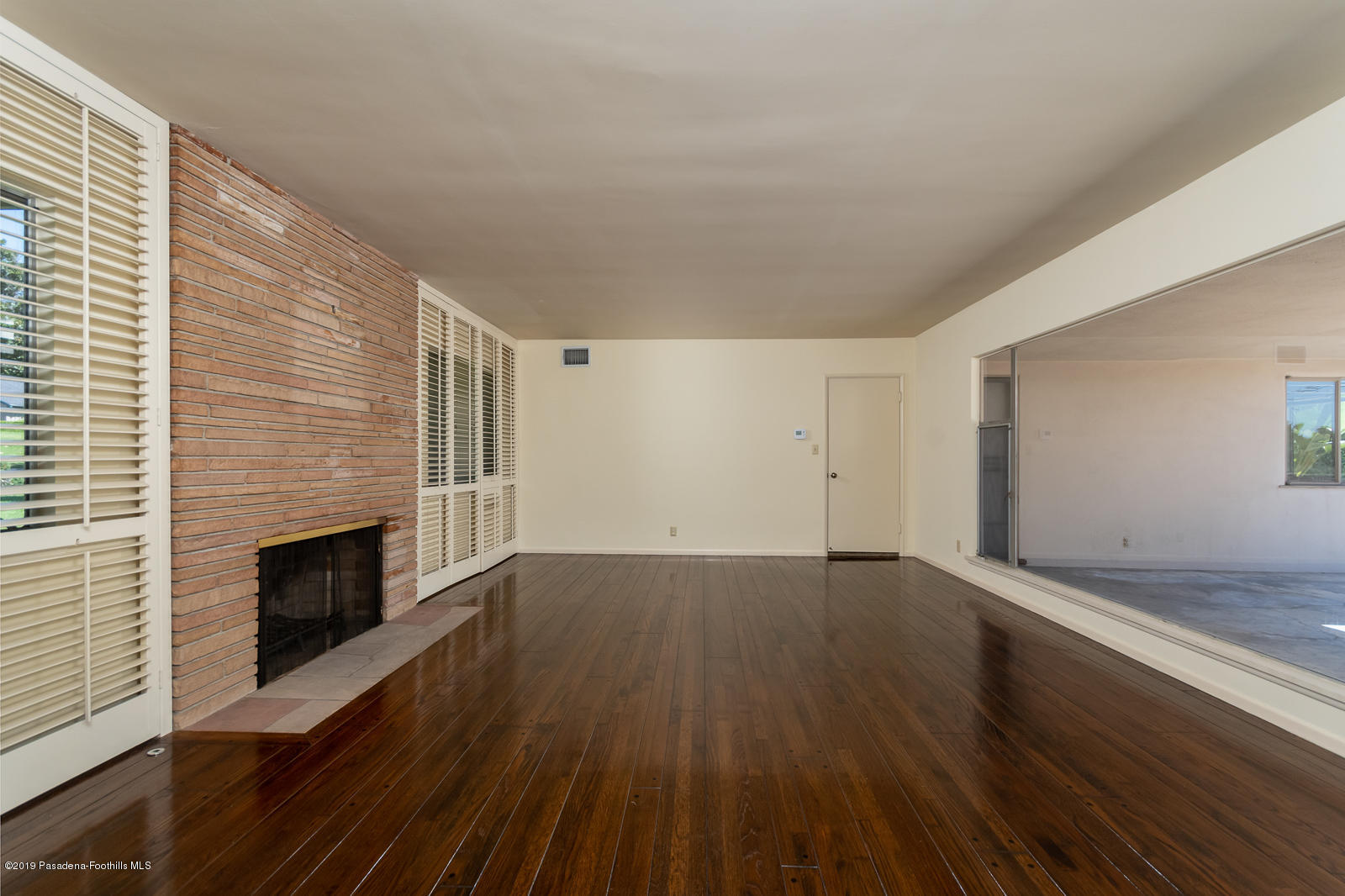 3810 Greenhill Road Pasadena, CA 91107 - Photo 8 of 29 an empty room with wooden floor and fireplace